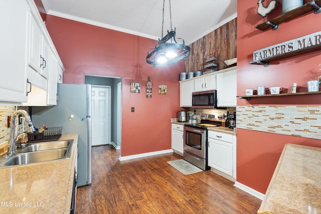 kitchen featuring appliances with stainless steel finishes, white cabinetry, sink, and hanging light fixtures