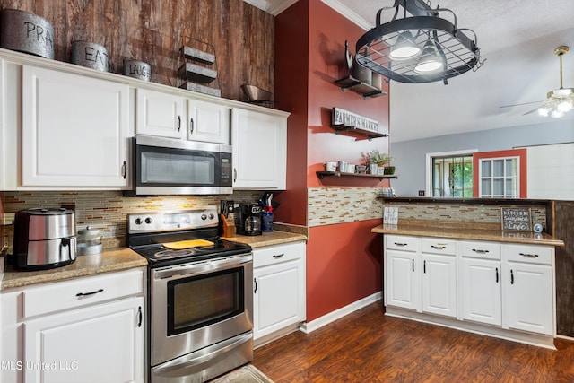 kitchen featuring tasteful backsplash, appliances with stainless steel finishes, white cabinets, ornamental molding, and dark hardwood / wood-style floors