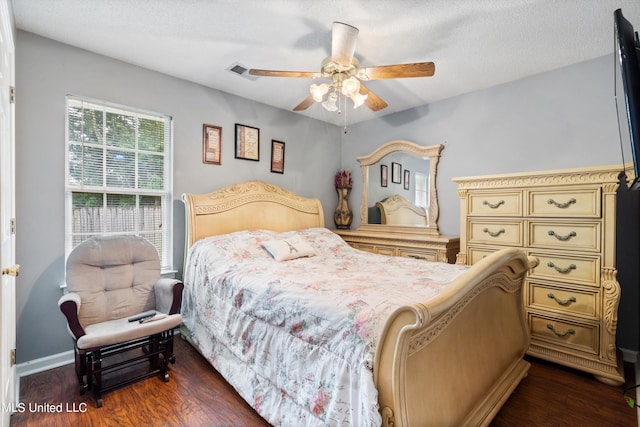 bedroom featuring a textured ceiling, dark wood-type flooring, and ceiling fan