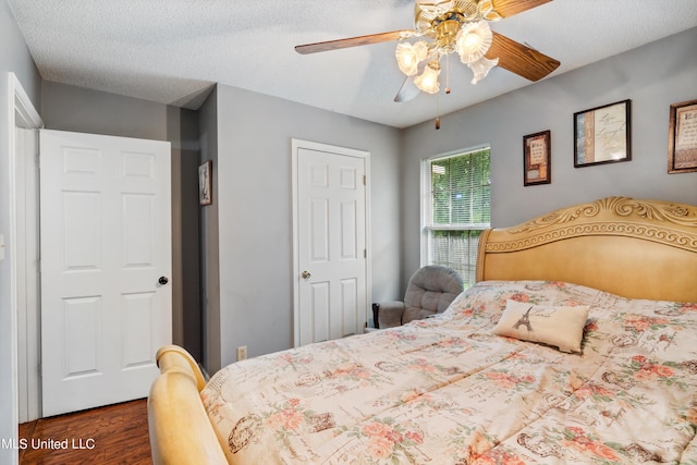 bedroom with dark hardwood / wood-style floors, a textured ceiling, and ceiling fan