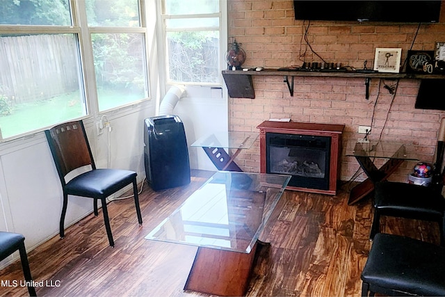 living room with brick wall and hardwood / wood-style floors