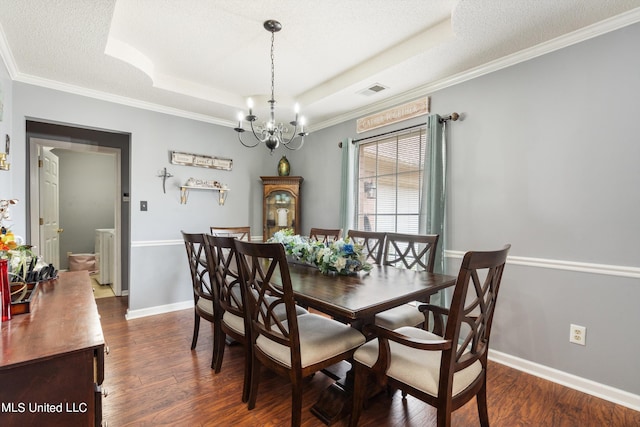 dining area with a tray ceiling, a textured ceiling, dark hardwood / wood-style flooring, and ornamental molding