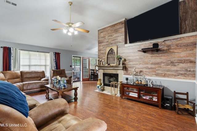 living room featuring a large fireplace, wood-type flooring, and ceiling fan