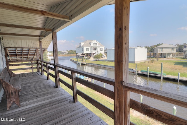 view of dock with a water view and a lawn