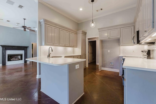 kitchen with sink, crown molding, hanging light fixtures, a kitchen bar, and kitchen peninsula