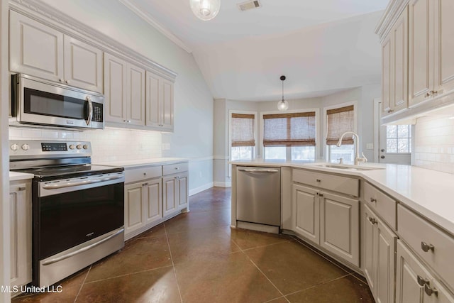 kitchen featuring sink, decorative light fixtures, dark tile patterned flooring, stainless steel appliances, and decorative backsplash