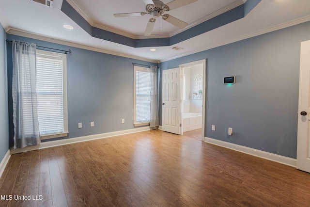 spare room with a tray ceiling, ornamental molding, ceiling fan, and hardwood / wood-style flooring