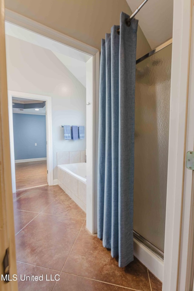 bathroom with independent shower and bath and tile patterned flooring