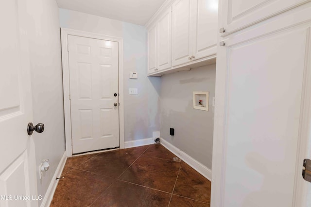 clothes washing area featuring cabinets, washer hookup, and dark tile patterned flooring