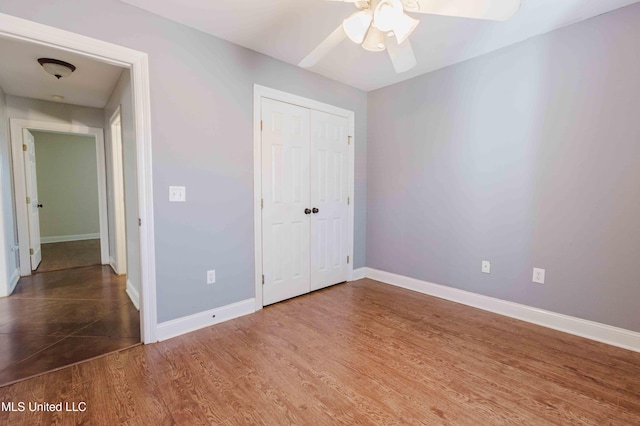 unfurnished bedroom with hardwood / wood-style floors, a closet, and ceiling fan