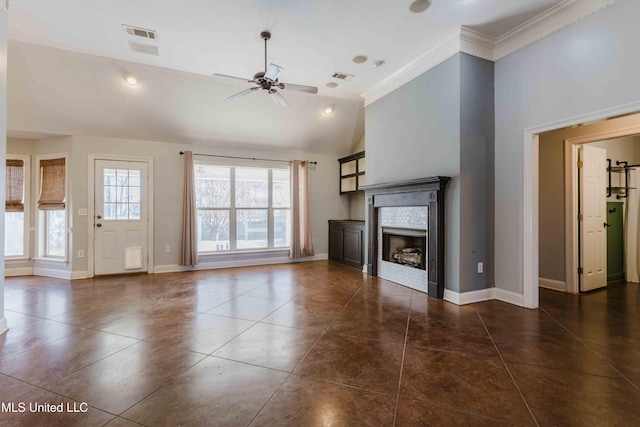 unfurnished living room featuring lofted ceiling, dark tile patterned floors, ceiling fan, a fireplace, and ornamental molding