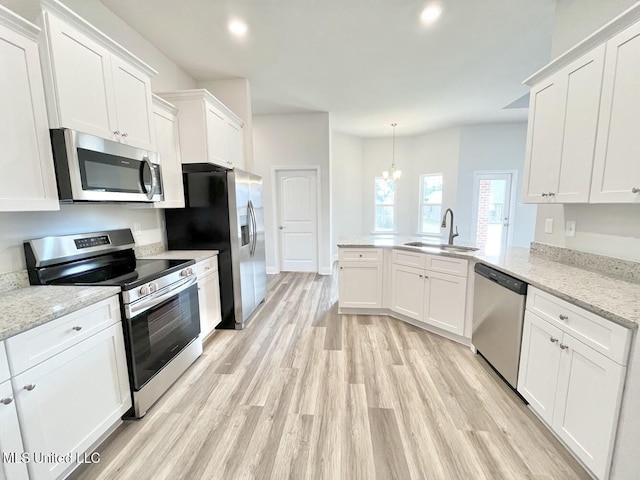 kitchen featuring a sink, light wood-style floors, a peninsula, appliances with stainless steel finishes, and white cabinetry