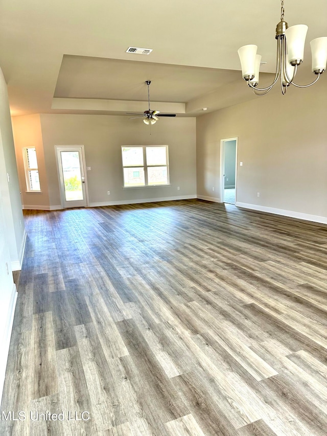 unfurnished living room with ceiling fan with notable chandelier and light hardwood / wood-style flooring