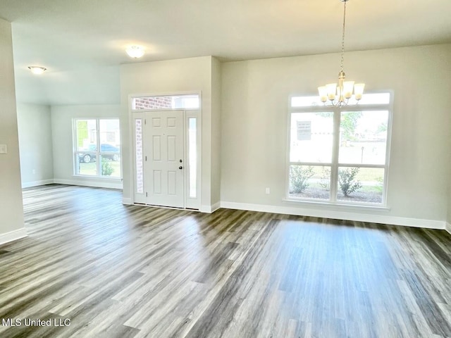 entrance foyer with wood finished floors, baseboards, and a notable chandelier
