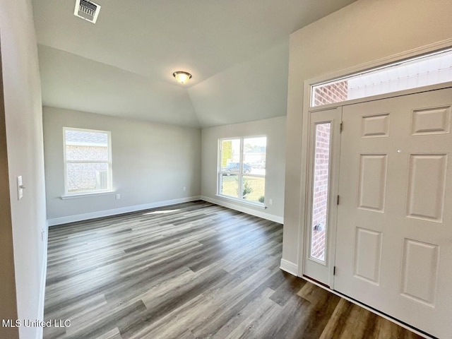 foyer featuring vaulted ceiling, visible vents, baseboards, and dark wood-style flooring
