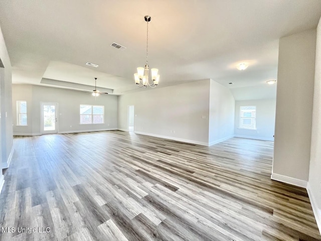 interior space with wood finished floors, visible vents, baseboards, and ceiling fan with notable chandelier