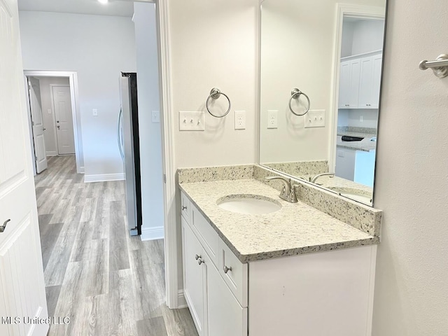 bathroom with baseboards, vanity, and wood finished floors