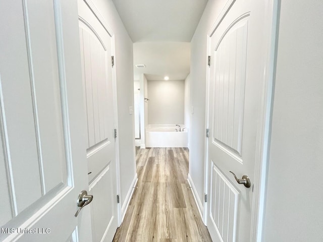 hallway with light wood-type flooring, baseboards, recessed lighting, and visible vents