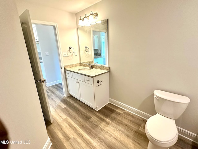 bathroom featuring hardwood / wood-style floors, vanity, and toilet