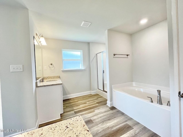 full bathroom with wood finished floors, visible vents, vanity, a bath, and a stall shower