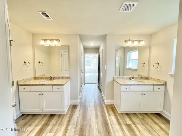 full bath with wood finished floors, visible vents, and a sink