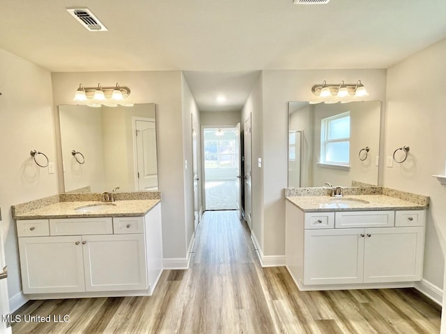 full bath featuring wood finished floors, visible vents, and a sink