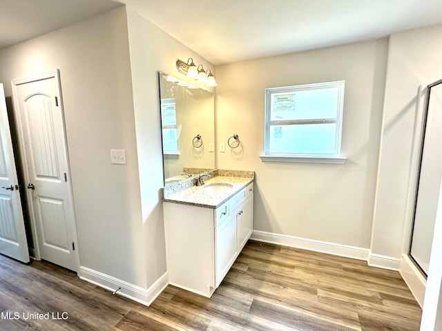 bathroom with hardwood / wood-style flooring, vanity, and walk in shower