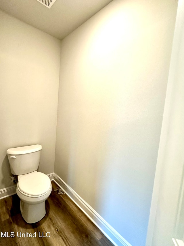 bathroom featuring hardwood / wood-style flooring and toilet