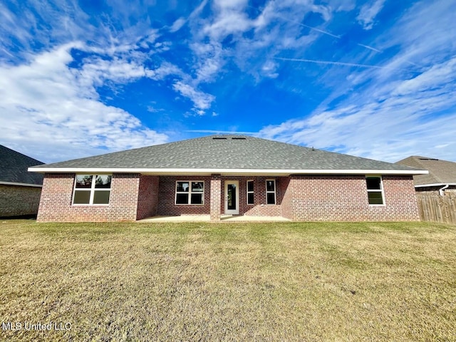 rear view of house featuring brick siding, a yard, and a patio