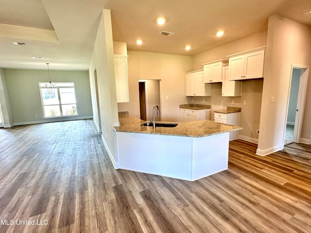 kitchen featuring white cabinetry, kitchen peninsula, sink, and light hardwood / wood-style flooring