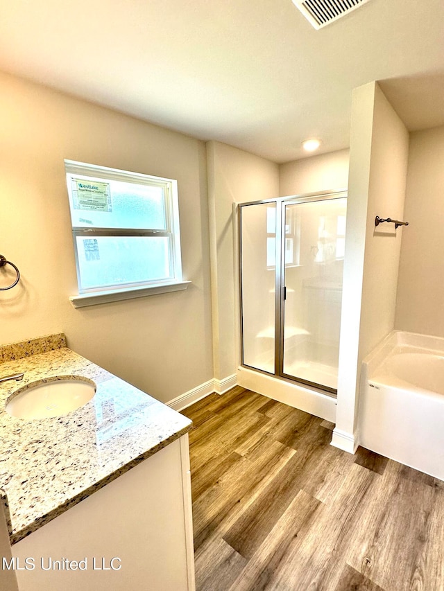 bathroom featuring vanity, hardwood / wood-style flooring, and separate shower and tub