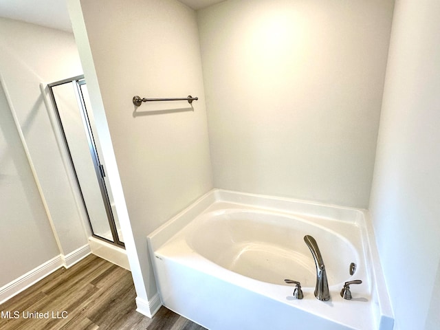 bathroom with shower with separate bathtub and hardwood / wood-style flooring