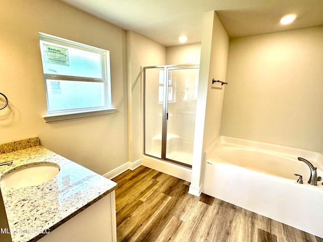 bathroom featuring vanity, wood-type flooring, and shower with separate bathtub