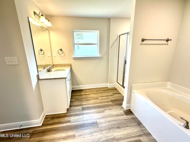 bathroom featuring hardwood / wood-style floors, vanity, and separate shower and tub