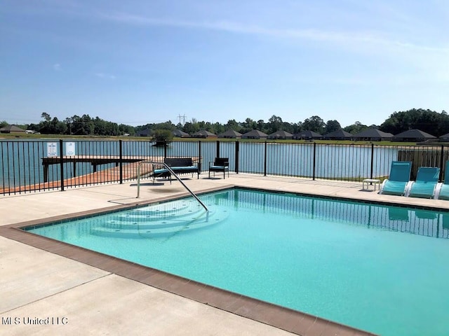 community pool with a patio area and fence