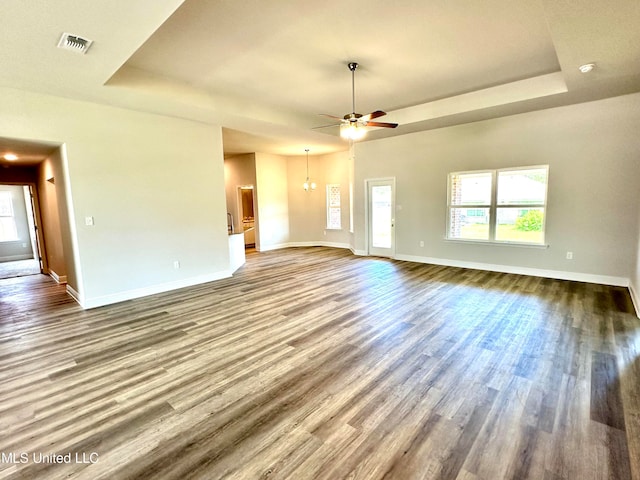 unfurnished living room featuring ceiling fan, wood-type flooring, and a tray ceiling