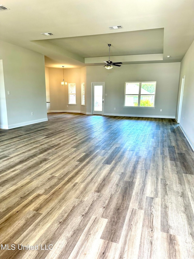 unfurnished living room with hardwood / wood-style flooring and ceiling fan with notable chandelier