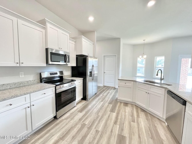 kitchen with white cabinets, recessed lighting, light wood finished floors, a sink, and appliances with stainless steel finishes