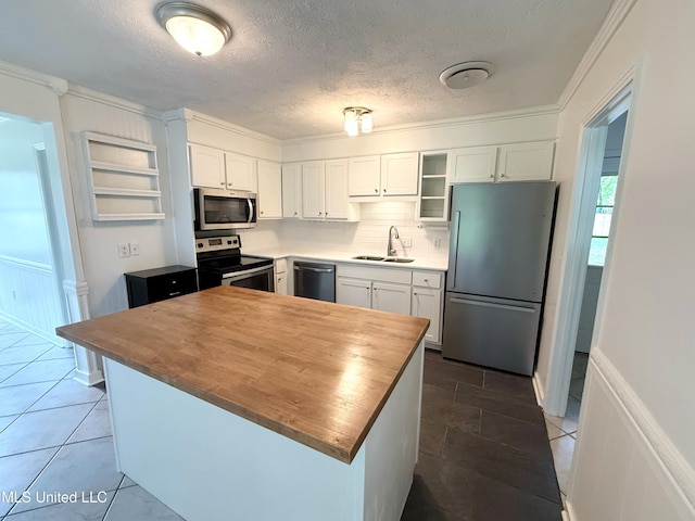 239 Traceland Dr, Madison, MS 39110 - kitchen with stainless steel appliances, wood counters, a sink, white cabinetry, and ornamental molding