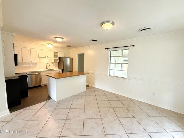 239 Traceland Dr, Madison, MS 39110 - kitchen with stainless steel appliances, a sink, ornamental molding, wood counters, and a center island