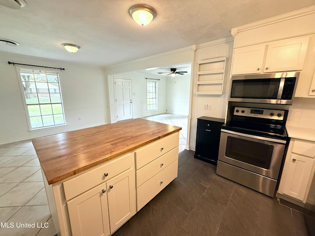 239 Traceland Dr, Madison, MS 39110 - kitchen with stainless steel appliances, butcher block countertops, open floor plan, a ceiling fan, and white cabinets