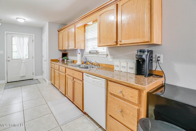 kitchen with light brown cabinets, dishwasher, sink, and light tile patterned floors