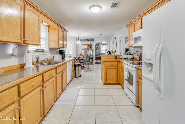 kitchen with white appliances, sink, kitchen peninsula, pendant lighting, and light tile patterned floors