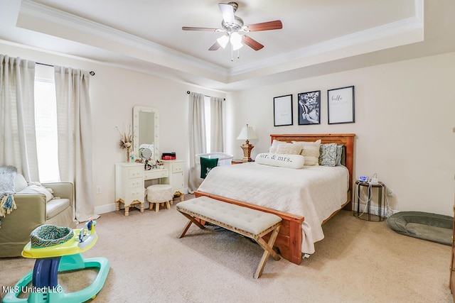 bedroom with ceiling fan, a tray ceiling, carpet, and multiple windows