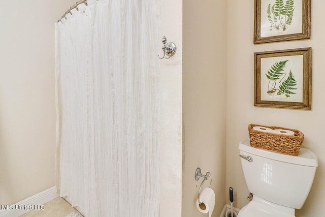 bathroom featuring tile patterned flooring, toilet, and walk in shower