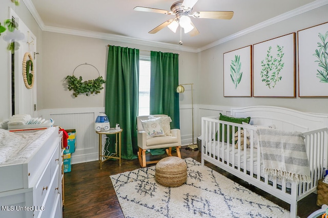 bedroom with ceiling fan, ornamental molding, dark hardwood / wood-style floors, and a nursery area