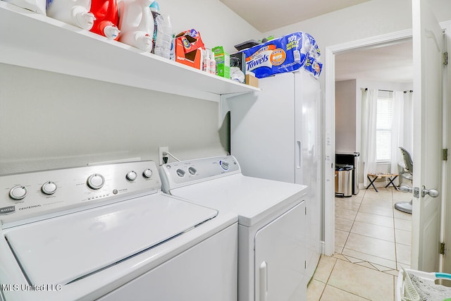 clothes washing area featuring washer and dryer and light tile patterned floors