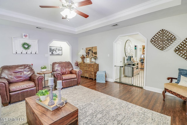 living room featuring ornamental molding, dark wood-type flooring, and ceiling fan