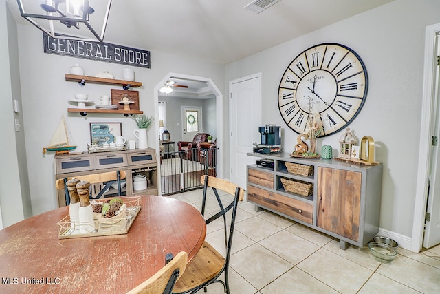 tiled dining room with ceiling fan with notable chandelier