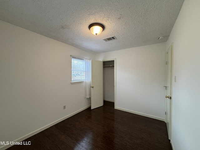 unfurnished room featuring dark hardwood / wood-style floors and a textured ceiling